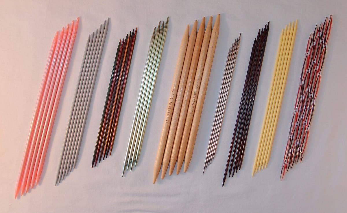 Double-pointed knitting needles in various sizes and materials, for the knitting needle size chart