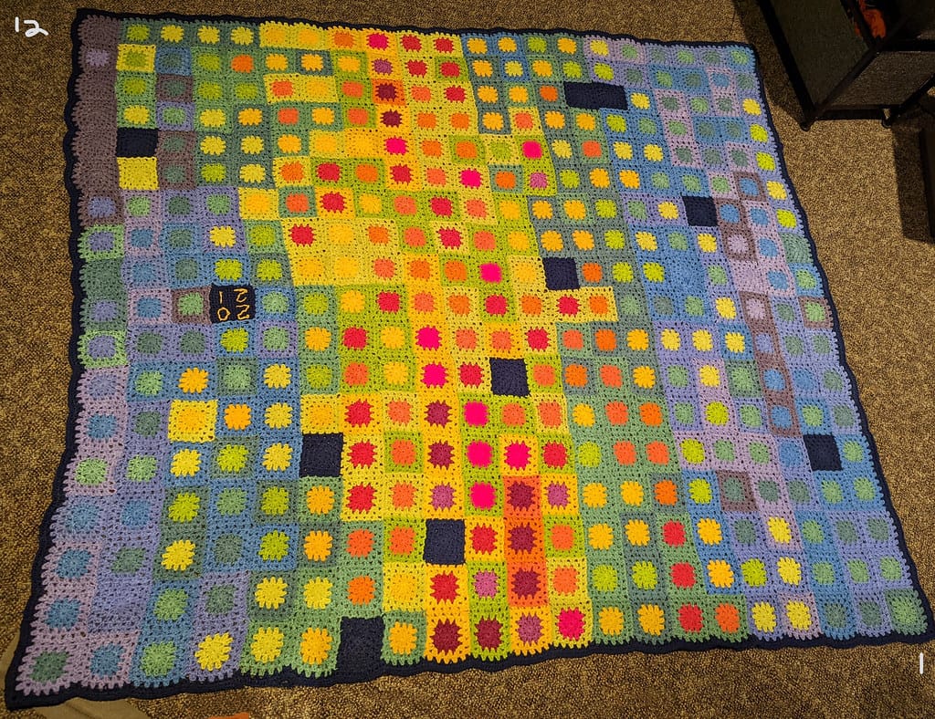 Crocheted temperature blanket with a granny square for each day, showing how to make a temperature blanket from warm and cool colors