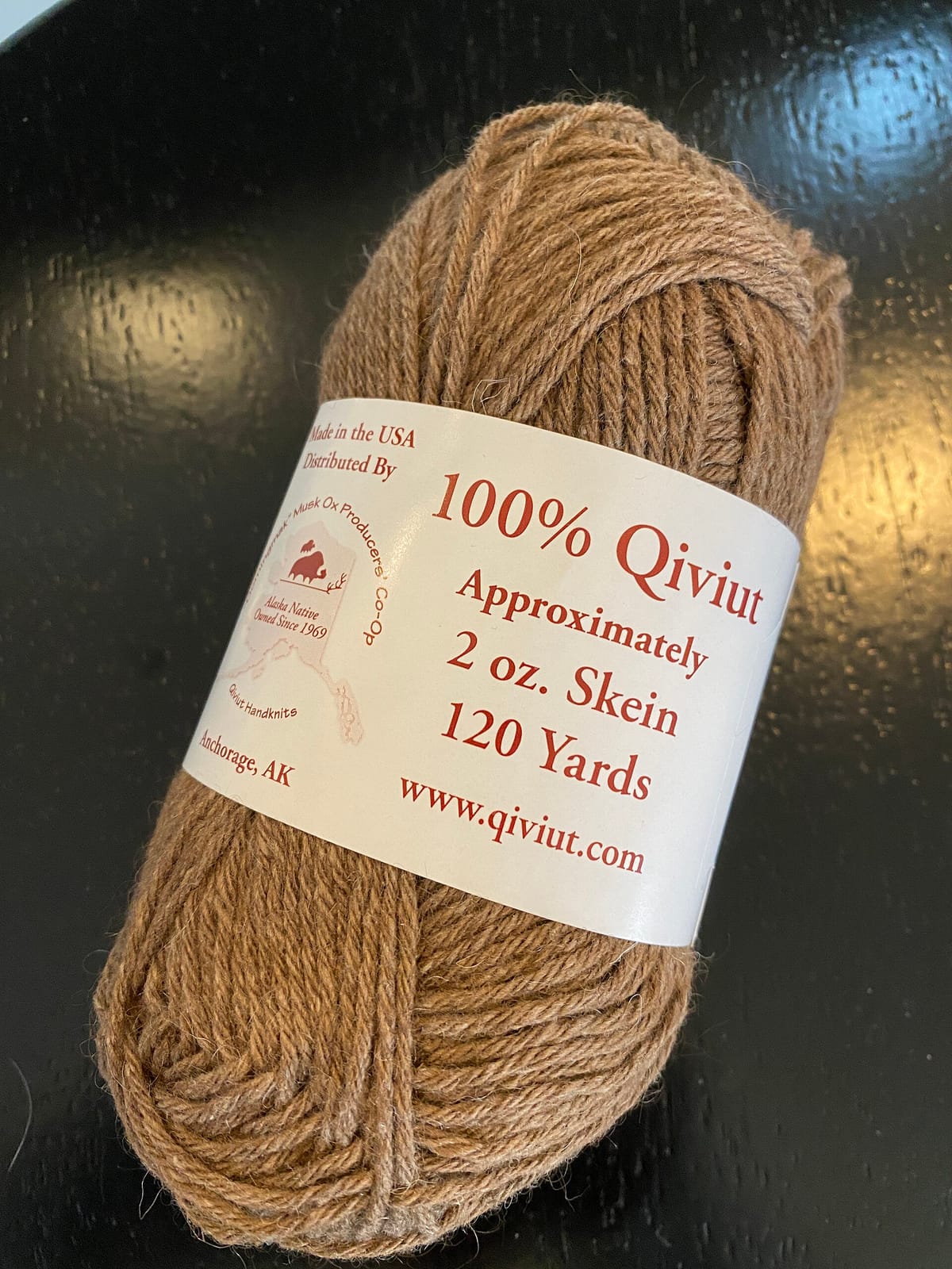 Skein of undyed qiviut yarn with a label reading 2 oz and 120 yards, one of many types of yarn